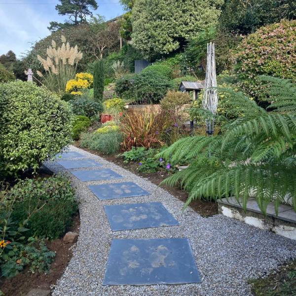 Terraced garden with wooden fencing, decking, and raised planting beds