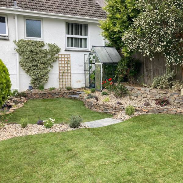 Garden pond with water lilies, stone edging and surrounding lush plants
